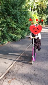 girl riding scooter by trees