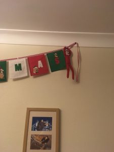 elf on the shelf hanging off Christmas bunting